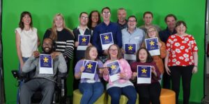 DigiAcademy participants and team members holding certificates in a group photograph.